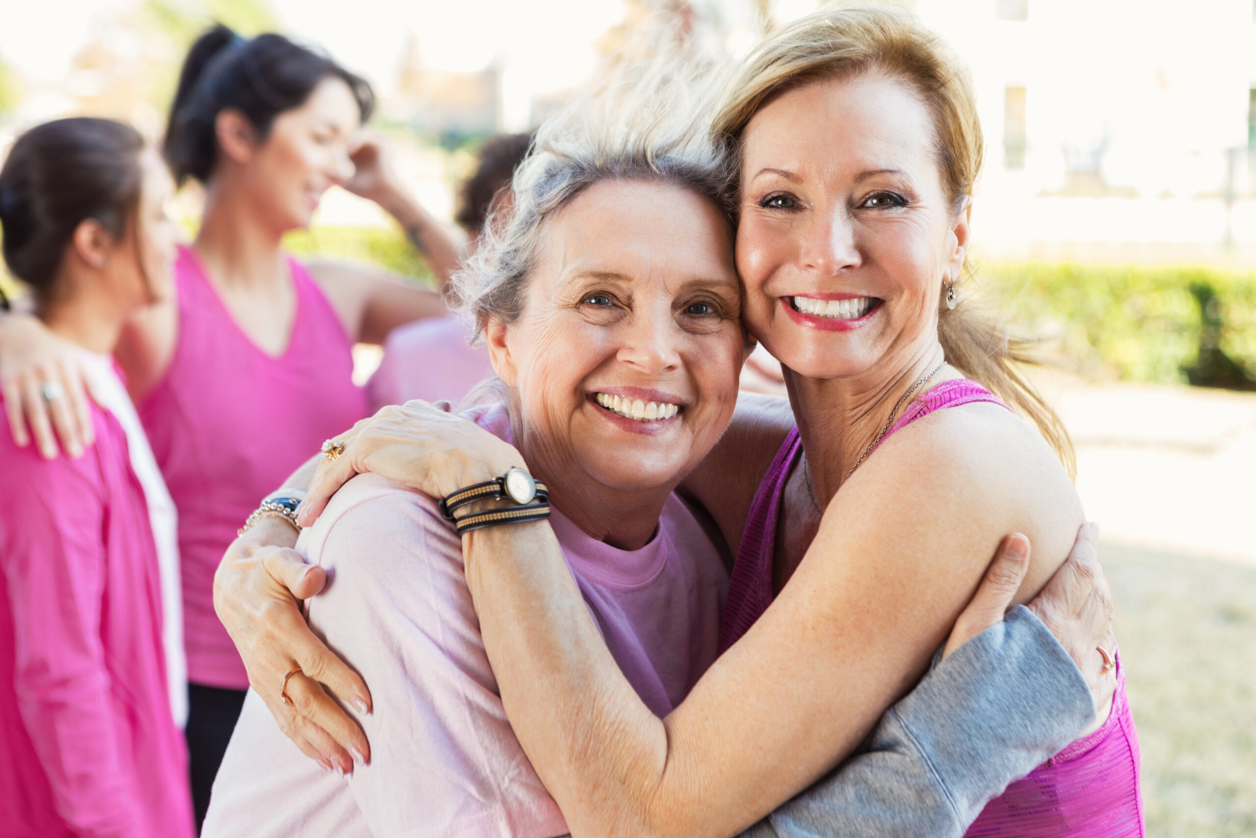 Two-women-hug-at-event-wearing-pink
